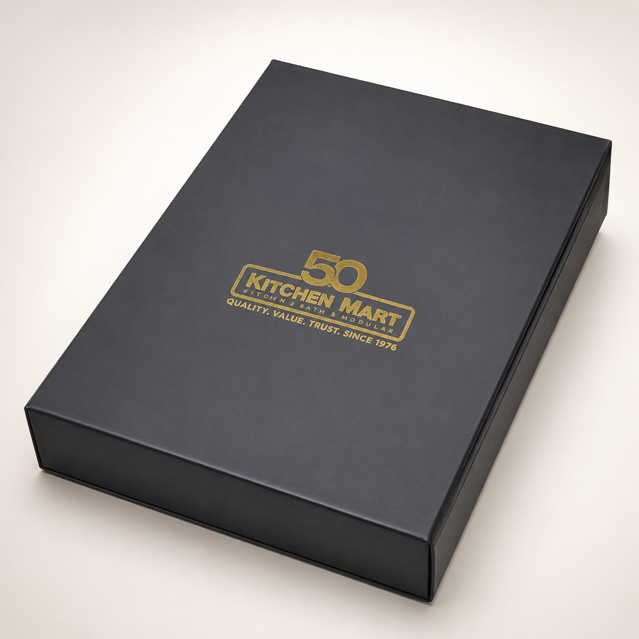 Closed matte-black rigid presentation box with a centered metallic-gold foil-stamped logo